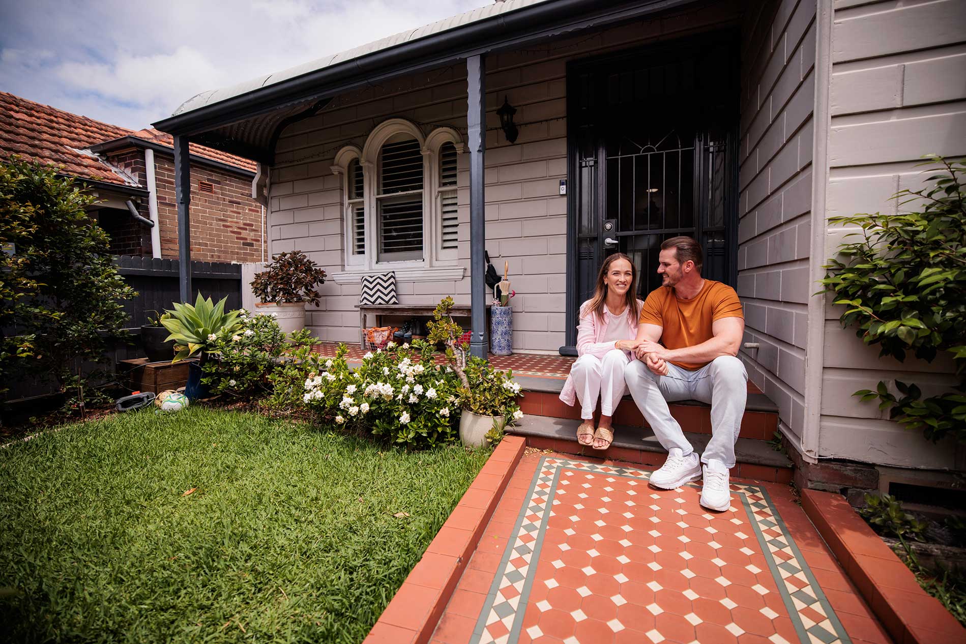 Couple sitting together on the front steps of their home