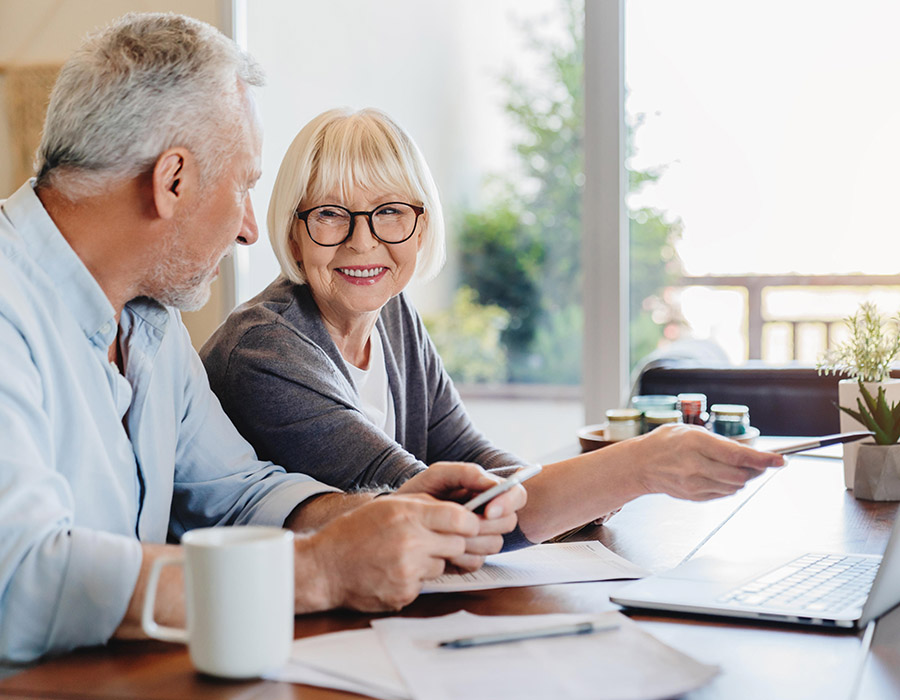 Retired couple reviewing their finances together at the kitchen table